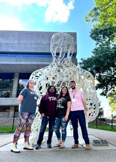有四个&移动商务 students in front of MIT art installation
